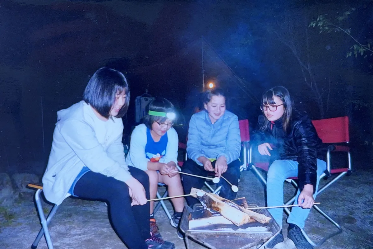 三景園で友人たちと焚き火を囲んでマシュマロを焼いている様子