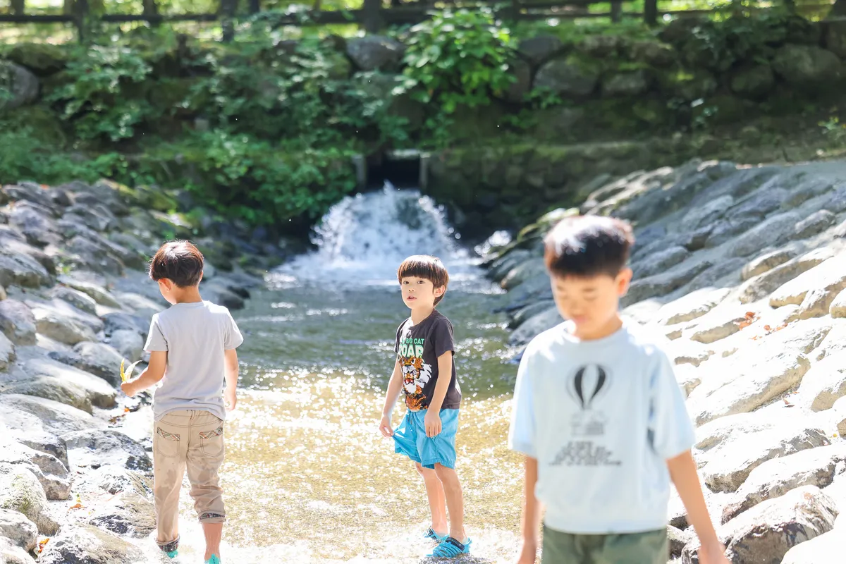 南アルプス三景園オートキャンプ場の川で水遊びをする子どもたち