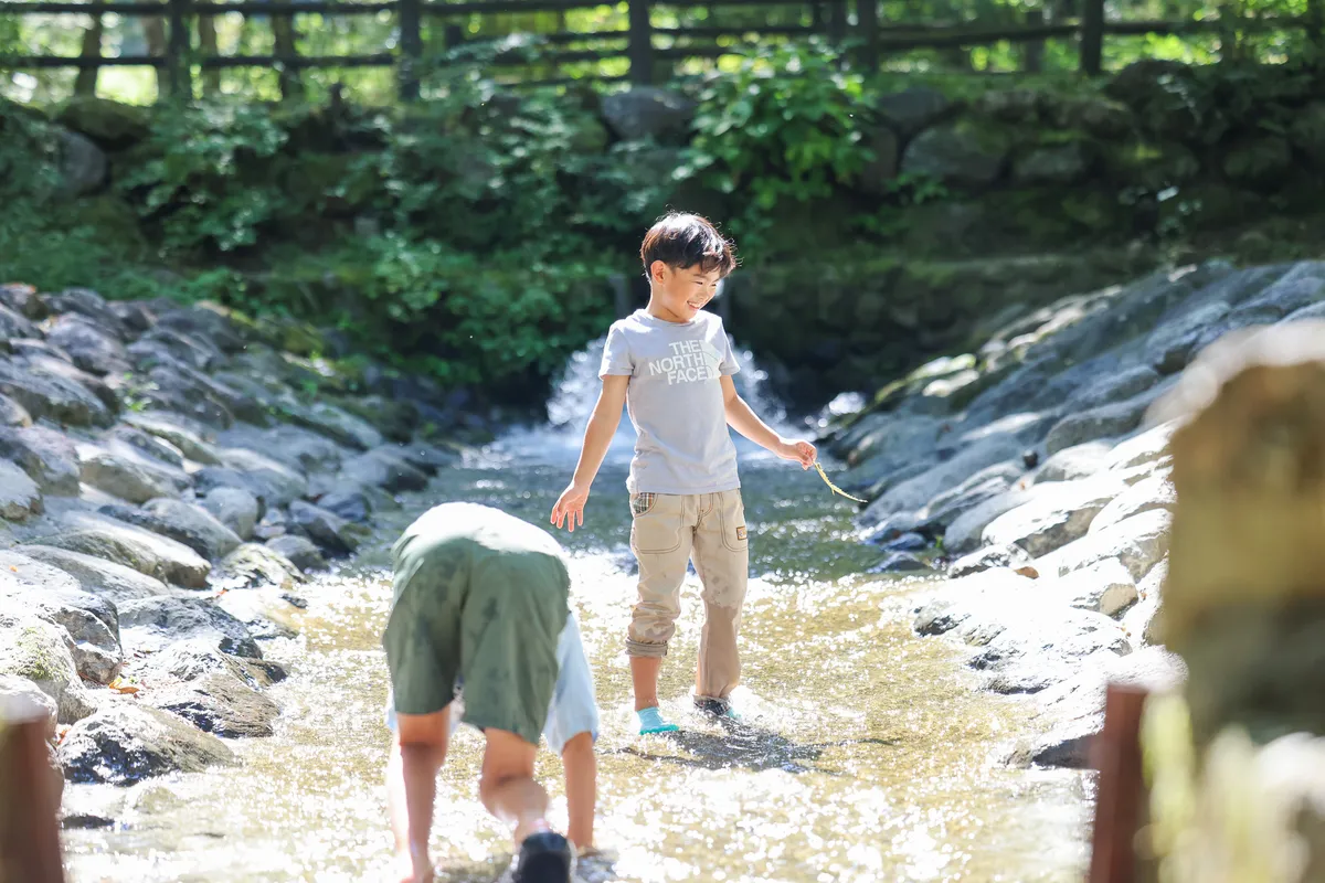 南アルプス三景園オートキャンプ場近くの川で水遊びをする子どもたち