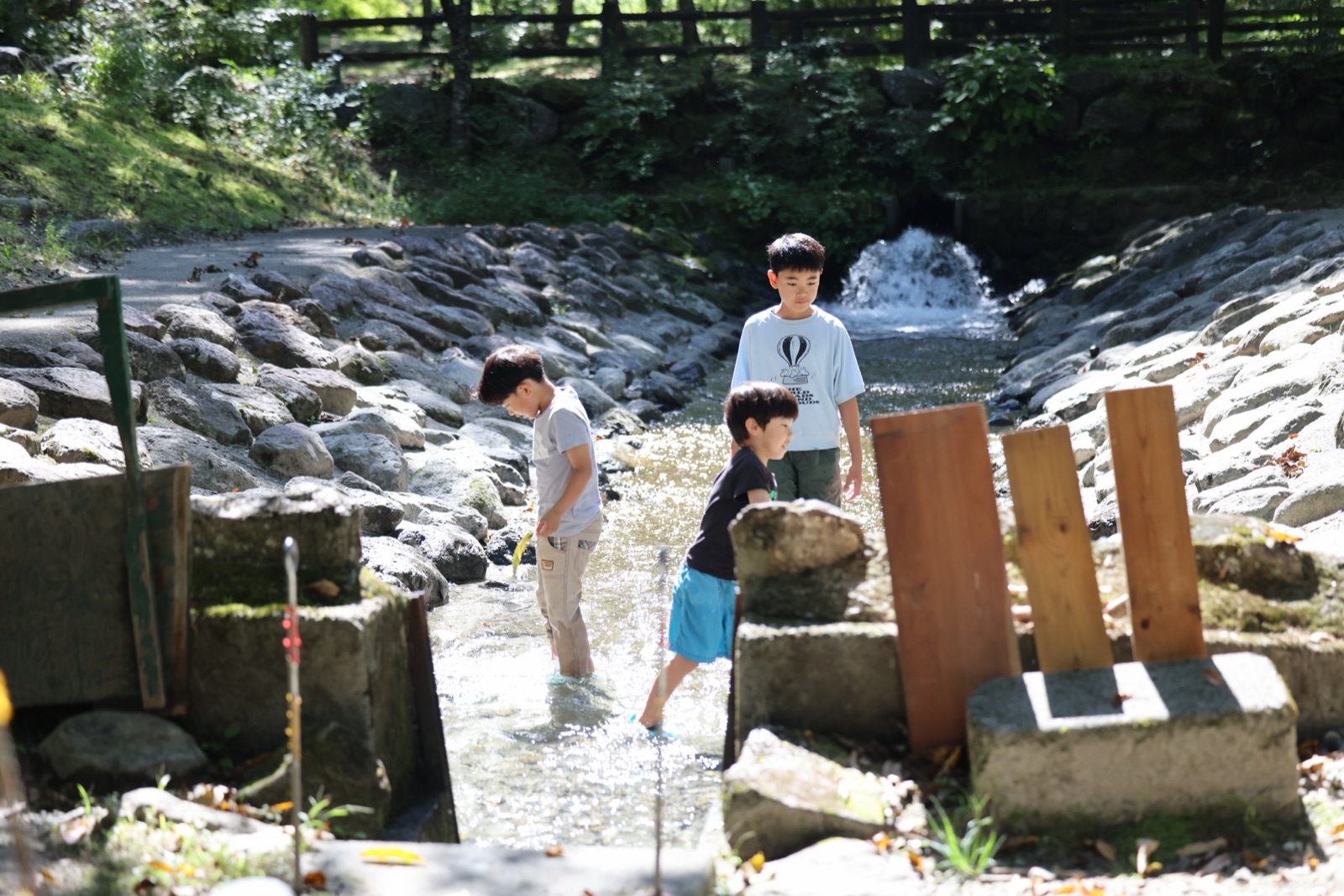 小さな滝のある浅瀬で遊ぶ子どもたち
